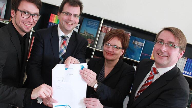 Thomas Kießlich, Bürgermeister Christian Lange, Claudia Lehnerer und Matthias Pfeufer präsentieren die unterschriebene Zielvereinbarung, die für eine neue Stabsstelle im neu eingerichteten Bildungsbüro sorgt (v.l.). Foto: Anna Lienhardt