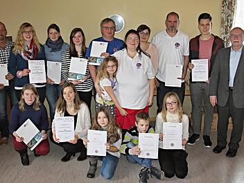 Waldemar Lutter (hinten Fünfter von links) ist als "alter Hase" seit 45 Jahren bei der BRK-Wasserwachtortsgruppe Ebern. Er wurde wie auch die anderen auf dem Foto von Kreisgeschäftsführer Dieter Greger (rechts) und der Ortsgruppenvorsitzenden Michaela Hülbig (stehend Fünfte von rechts) geehrt. Foto: Helmut Will