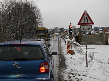 An der alten Sandsteinbrücke über den Main steht seit gestern wieder eine Ampel. Rechts ist das neue Bauwerk zu sehen. Foto: Alexander Hartmann