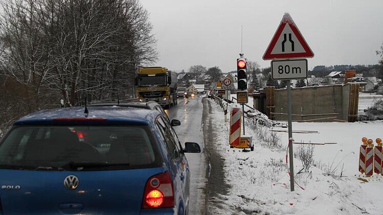 An der alten Sandsteinbrücke über den Main steht seit gestern wieder eine Ampel. Rechts ist das neue Bauwerk zu sehen. Foto: Alexander Hartmann