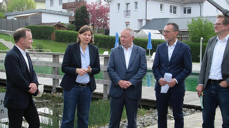 "Kleine Schwimmbäder sind oft sanierungsbedürftig und das geht ins Geld. Deswegen werden sie meist geschlossen", wusste Staatssekretärin Manuela Rottmann (2. v. l.) die mitDVS- Moderator Moritz Kirchesch, Landrat Thomas Bold, Bürgermeister Thomas Hack und DVS-Moderator Stefan Kämper (v. l.) das Auraer Naturbad besuchte.