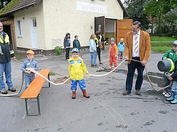 Die Feuerwehr Eila führte eine Feuerwehr-Kinderolympiade durch. Mit den begeisterten Kids sind vorne am Schlauch 1. Kommandant Clemens Wicklein (links) und 2. Bürgermeister Arno Hoffmann. Foto: K.- H. Hofmann