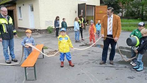 Die Feuerwehr Eila führte eine Feuerwehr-Kinderolympiade durch. Mit den begeisterten Kids sind vorne am Schlauch 1. Kommandant Clemens Wicklein (links) und 2. Bürgermeister Arno Hoffmann. Foto: K.- H. Hofmann