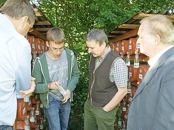 Der Doktorand Sebastian Vogel (Zweiter von links) erl&auml;utert sein Forschungsprojekt Landtagsabgeordnetem Hans-J&uuml;rgen Fahn (rechts), dem Leiter des Forstbetriebs Ebrach, Ulrich Mergner (Zweiter von rechts), und Rauhenebrachs B&uuml;rgermeister Matthias B&auml;uerlein (links). Hier der Versuchsaufbau im Garten der &ouml;kologischen Station.  Foto: sw
