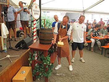 Bürgermeister Johannes Krumm (Mitte) gelang sein erster Bieranstich beim zweiten Schlag. Gemeinderat Tobias Warter (rechts) wartet bereits mit den Freibier-Krügen.
