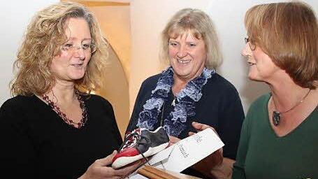 Eine ungewöhnliche Trophäe: Gewinnerin Christine Ponnath (links) bekam von Jutta Lange (rechts) einen selbstgetöpferten Schuh. Glückwünsche gab es auch von Karin Minet vom Literaturverein.
