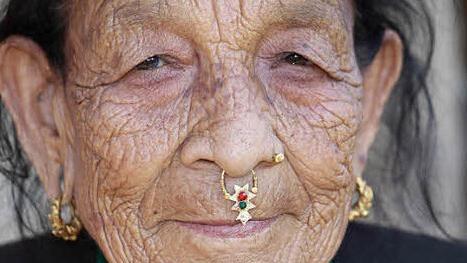 Das Gesicht einer alten Frau aus Nepal, die den typischen Schmuck des Landes trägt. Foto: Raimund Göhlich