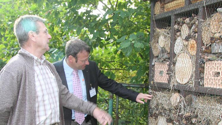 Robert Strunz (links), der Vorsitzende der Kleingärtner, zeigt der Bewertungskommission das Insektenhotel.