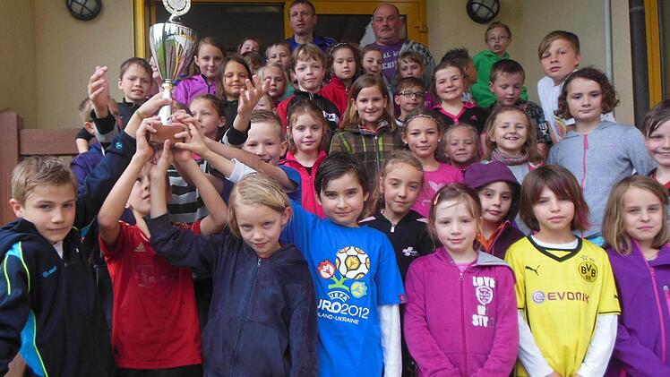 Die teilnehmenden Mannschaften nach der Siegerehrung bei der "Mini-Weltmeisterschaft" der Grundschule Rentweinsdorf und dem Sportverein Heubach. Links das Siegerteam Brasilien und ganz oben rechts Turnierleiter Gerald Streng und Elternbeirat Günter Forkel. Foto: Wolfgang Dietz