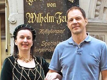 Hoflieferanten wie die Konditorei Feyler durften sich mit dem herzoglichen Wappen schmücken. Nora Meixner führt als Hofdame Nora von Hirsch auf Gereuth zu den Coburger Hoflieferanten, Peter Feyler hält die Tradition hoch. Foto: Simone Bastian