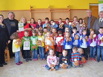 Die Kinder vom Kindergarten Gundelsdorf sind stolz auf ihr Zertifikat "Haus der kleinen Forscher" und zeigen die Teddybären und Medaillen, die es als Belohnung für die kleinen Forscher gab. Mit im Bild von links Andrea Wild (IHK), Pater Waldemar Brysch, Birgit Eisentraudt (Leitung Kindertagesstätte), und (von rechts) Fred Wunder (IHK) und Dritter Bürgermeister Hans Simon Foto: Karl-Heinz Hofmann