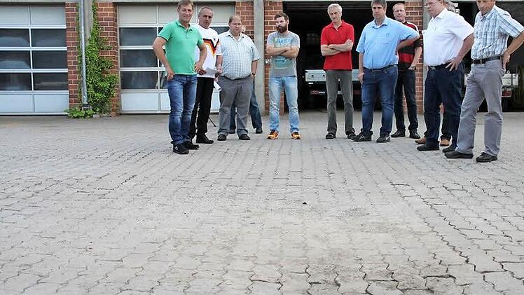 Die jahrelange Belastung durch die Fahrzeuge des Winterdienstes haben ihre Spuren hinterlassen. Auf dem Hof des gemeindlichen Bauhofs senken sich die Pflastersteine (vorne im Bild). Bauhofleiter Alexander Schmidt (Vierter von links) schlug vor, den Hof zu asphaltieren.  Foto: Stephan Stöckel