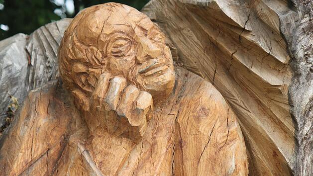 Ein in sich gekehrter Pilger rastet am Weg - diese Holzskulptur von Heinz Hubert Günther steht an einem Feldweg bei Schönbrunn und ist Teil des offiziellen Pilgerwegs Untermerzbach-Vierzehnheiligen, den Reinhold Müller bei seinen Touren teilweise nutzt. Foto: Matthias Einwag