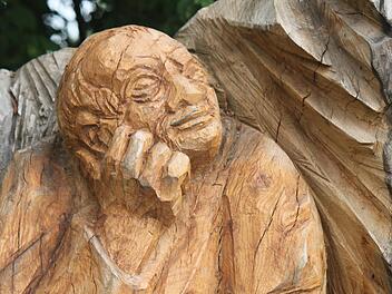 Ein in sich gekehrter Pilger rastet am Weg - diese Holzskulptur von Heinz Hubert Günther steht an einem Feldweg bei Schönbrunn und ist Teil des offiziellen Pilgerwegs Untermerzbach-Vierzehnheiligen, den Reinhold Müller bei seinen Touren teilweise nutzt. Foto: Matthias Einwag
