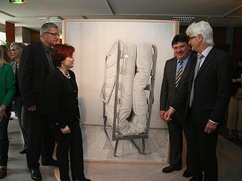 Das Klappbett symbolisiert, dass Menschen Fremde beherbergen sollen. Stellvertretende Landrätin Christina Flauder, Günter Breitenbach von der Rummelsberger Diakonie, Landrat Klaus Peter Söllner und Fritz Glock (von links) bestaunen das Kunstwerk von Martin Schmidt. Foto: Sonja Adam