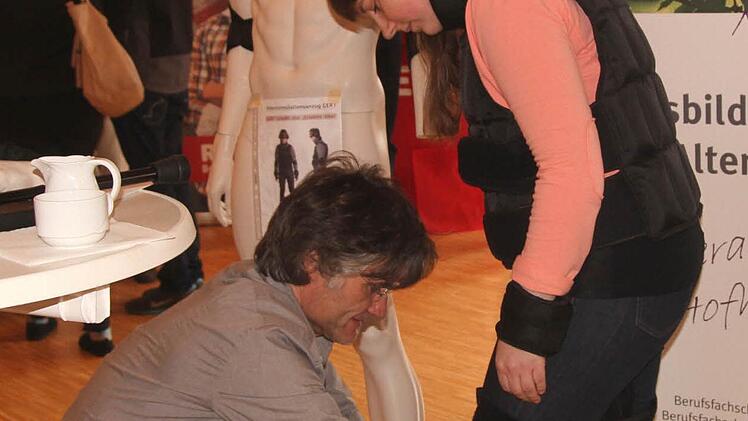 Die Organisatorin und Vorsitzende der Jungen Union Cynthia Derra (rechts) beim Testen von Schutzkleidung für die Altenpflege.