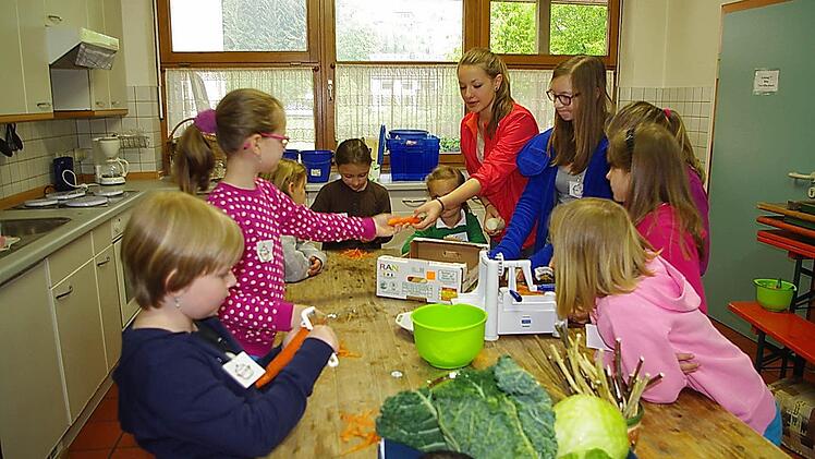 Kim Werner und Lea Neubauer (stehend, von links) bereiteten mit den Kindern eine bunte Salatplatte zu. Foto: Heike Schülein