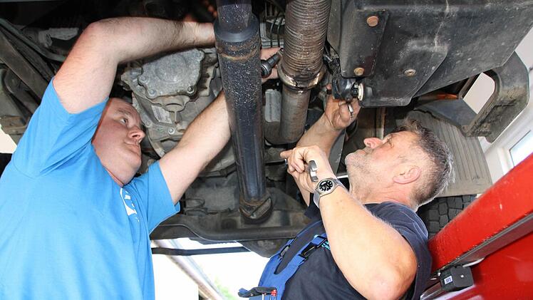 Matthias Heil (links) und Winfried Brand reparieren ein Fahrzeug in der neuen Werkstatt. Foto: Ralf Ruppert