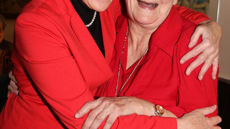 Zwei Frauen in Rot: MdL Inge Aures herzt Jubilarin Alma Taubenreuther zum 80. Geburtstag.