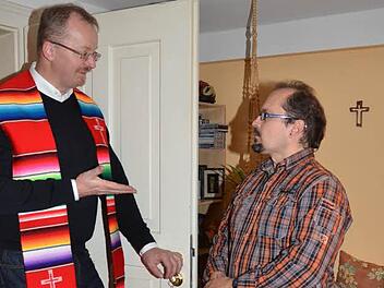 Stadtpfarrer Thomas Teuchgräber im Gespräch mit Udo Bartmann in dessen neuer Wohnung im Caritashaus. "Es kann schon mal passieren, dass sie mich auf Händen gehend im Kopfstand die Treppen von der Stadtpfarrkirche hinunter zum Stadtgraben gehen sehen", erklärte der ehemalige Kunstturner Bartmann dem Stadtpfarrer voller Freude. Foto: K.-H. Hofmann