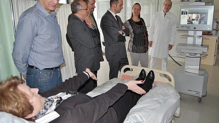 Bad Brückenaus Bürgermeisterin Brigitte Meyerdierks befindet sich als Testpatientin im Videogespräch mit dem Neurologen Peter Kraft von der Universitätsklinik Würzburg. Chefarzt Tobias Goebel und Meyerdierks' Kollegen beobachten die Situation. Foto: Sigismund von Dobschütz