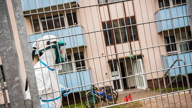Ein Brandermittler der Polizei geht im Vollschutz am 15.11.2017 in Bamberg auf dem Gelände der zentralen Aufnahmeeinrichtung für Asylbewerber zu einem Wohnhaus. Bei einem Brand in der Asylunterkunft ist am frühen Mittwochmorgen ein Mensch ums Leben gekommen. Foto: Nicolas Armer/dpa