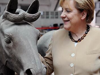 Bundeskanzlerin Angela Merkel steht in Xi'an (China) neben einem Pferd der Terrakottaarmee. Am 31. Januar 2014 beginnt laut Chinas klassischem Kalender das Jahr des Pferdes. Stark aber stur sollen Pferde sein. Merkel stammt aus einem Pferdejahr. Foto: Rainer Jensen/dpa