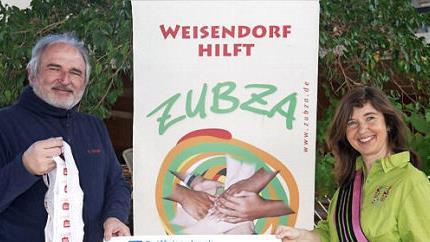 Matthias Zwingel vom gleichnamigen Rewe-Markt &uuml;bergibt den Erl&ouml;s an Regina Lehninger.