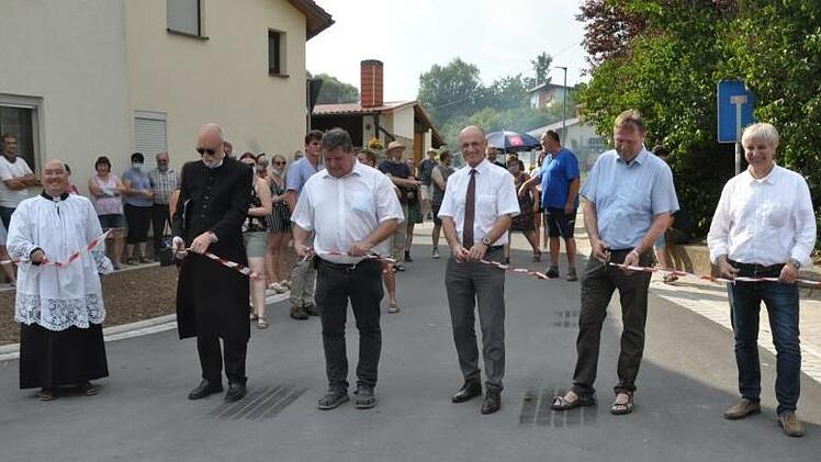 Schnipp-schnapp: Manfred Rott , Adolf Schanz Landrat Wilhelm Schneider, Bürgermeister Hermann Niediek, Pfarrer Wolfgang Scheidel und Pfarrvikar Ninh (von rechts) geben symbolisch die Ortsdurchfahrt frei