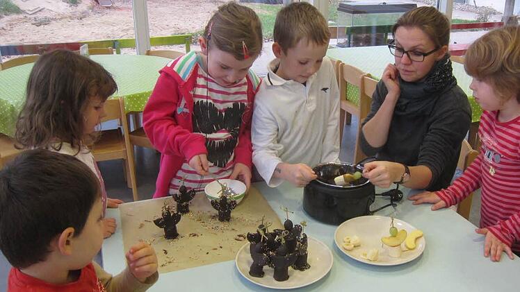 Die Vorbereitungen für den Weihnachtsmarkt laufen im Westheimer Kindergarten auf Hochtouren. Emil, Luisa, Sina, Nils, Kinderpflegerin Bianca Pfannes, und Sophia (von links) haben schon fleißig Schokoengel aus Obst gemacht.  Fotos: Carmen Newell