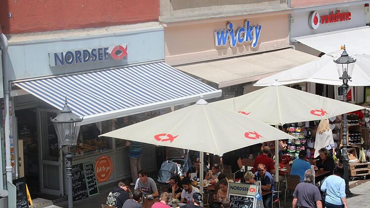 Ein Bild aus unbeschwerten Sommertagen in der Spitalgasse: Bei der "Nordsee" sitzen viele Gäste, und nebenan bei "Wicky" wird nach Geschenkartikeln gestöbert. Nun kommt das "Aus" für beide.CT-Archiv / Oliver Schmidt