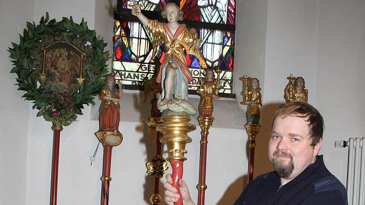 Mesner Andreas Dremer - im Bild mit dem heiligen Michael - hat es sich zur Aufgabe gemacht, die Zunftstäbe sanieren zu lassen. Foto: Sopnja Adam