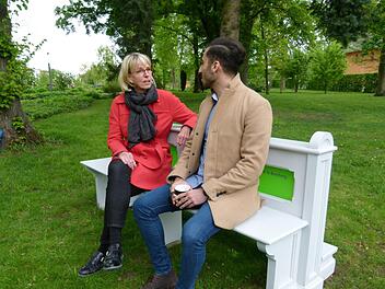 Projektleiterin Susanne Röhner im Gespräch mit einem Spaziergänger, der sich von der Kirchenbank im Historischen Garten der Erba-Insel anlocken ließ.  Foto: Marion Krüger-Hundrup