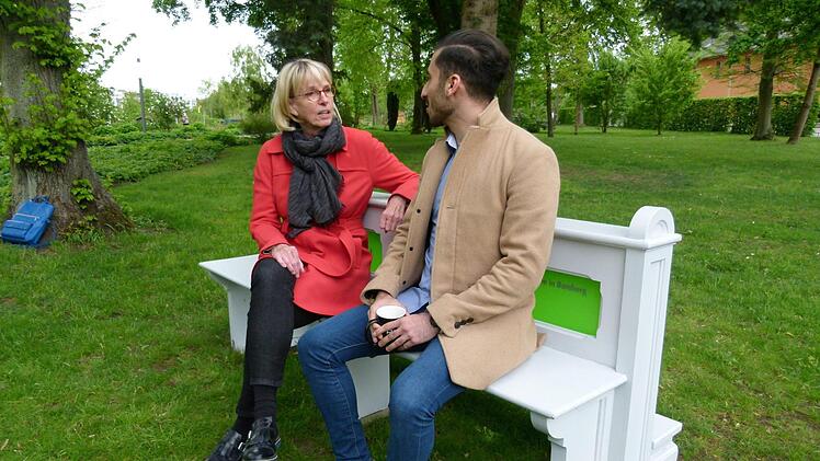 Projektleiterin Susanne Röhner im Gespräch mit einem Spaziergänger, der sich von der Kirchenbank im Historischen Garten der Erba-Insel anlocken ließ.  Foto: Marion Krüger-Hundrup