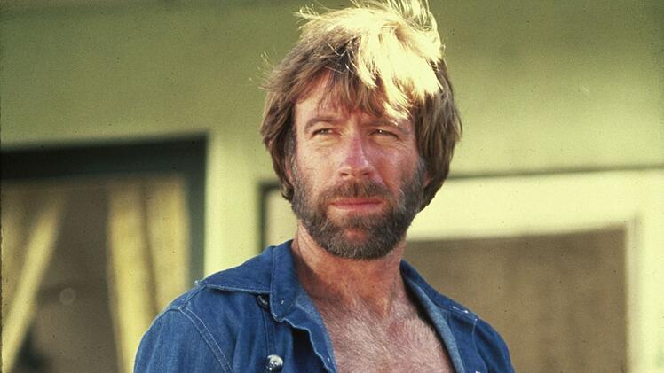Wann ist ein Mann ein Mann? Wenn er wie Chuck Norris ist: m&auml;nnlich, dass selbst seine Brusthaare Brusthaare haben, wie es in einem "Chuck Norris Fact" hei&szlig;t. Das Bild zeigt den Schauspieler in einer Szene des Actionsfilms "McQuade, der Wolf" (1983)