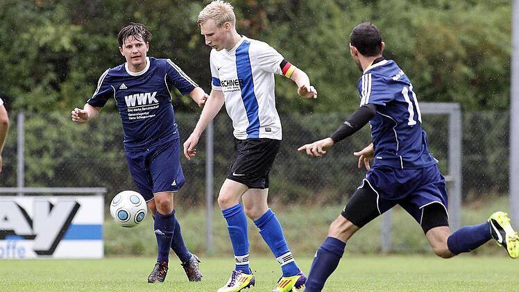 Sebastian Stein hat noch Zeit zum Abspiel, auch wenn die Trailsdorfer Benedikt Rundel (l.) und Ali Sakli schon heranpreschen. Foto: sportpress