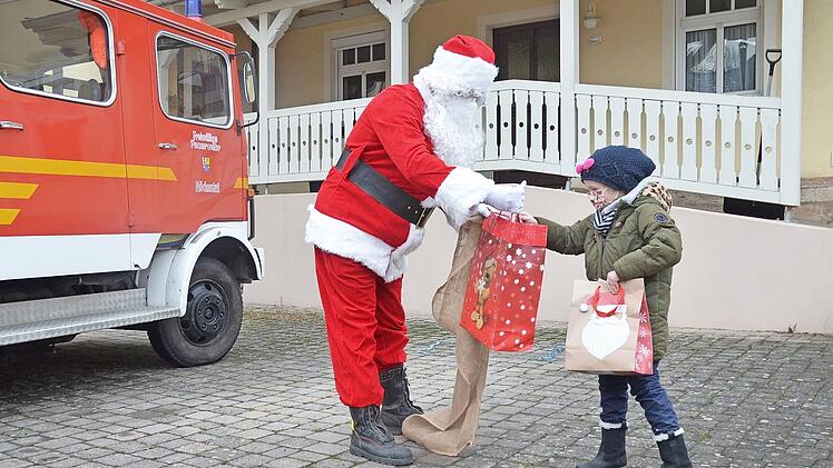 Nikolaus Sebastian Ehrlicher überreicht der kleinen Klara-Maria ihre Geschenke.