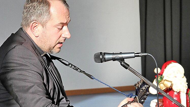Pfarrer Michael Kubatko spielte auf der Gitarre einige Weihnachtslieder für  die Behinderten. Foto: Britz