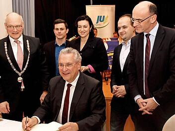 Minister Joachim Herrmann beim Eintrag ins "Goldene Buch" der Stadt Hofheim mit (von links) Bürgermeister Wolfgang Borst, JU-Vorsitzendem Felix Hein, Staatssekretärin Dorothee Bär, JU-Kreisvorsitzendem Fabian Weber und Landrat Wilhelm Schneider. Foto: Geiling