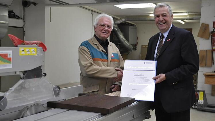 Seit fünf Jahrzehnten ist Gisbert Reuss (links) mit Leib und Seele Schreinermeister. Jetzt überreichte ihm Kreishandwerksmeister Werner Paltian den "Goldenen Meisterbrief" der Handwerkskammer für Unterfranken.   Foto: Peter Klopf