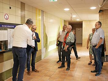 Bauleiter Mustafa Zecic (links) und Bürgermeister Michael Kastl zeigen, wie die Wand im Eingangsbereich aussehen könnte. Die Fliesen sollen eigentlich bleiben, aber es gibt Stellen, wo etwas Neues hin muss.