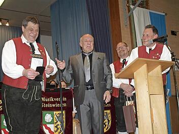 Eine kleine Überraschung zum 30-jährigen Dirigentendasein: Wolfgang Schrepfer (links) bekam vom Vorsitzenden des Musikvereins Steinwiesen, Stefan Hümmer (2. v. links) und seinem Stellvertreter Frank Hauck (rechts) einen goldenen Dirigentenstab überreicht. Foto: Susanne Deuerling