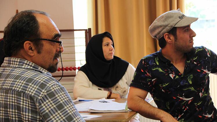 Diese Familie aus Afghanistan hört aufmerksam zu. Das Bild zeigt Vater, Mutter und den erwachsenen Sohn. Foto: Ulrike Müller