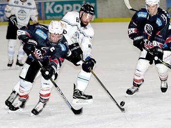 Der Haßfurter Christian Dietrich (links) im Duell um den Puck mit dem Freisinger Manuel Kühnl; rechts Lukas Kratschmer. Fotos: Ralf Naumann