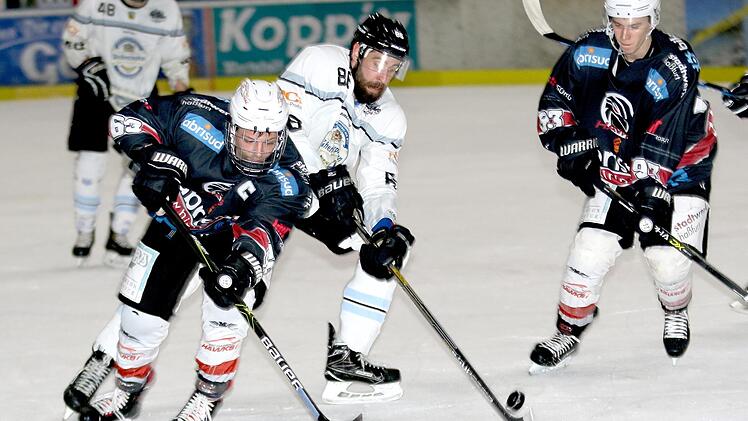 Der Haßfurter Christian Dietrich (links) im Duell um den Puck mit dem Freisinger Manuel Kühnl; rechts Lukas Kratschmer. Fotos: Ralf Naumann
