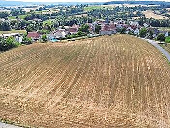 Auf diesem Acker gleich hinter der Kirche sollen einmal 20 Wohnhäuser gebaut werden können. Angesichts der steigenden Bau- und Energiepreise hat Bürgermeister Oppelt für Donnerstag zu einer Bürgerversammlung eingeladen, um das weitere Vorgehen mit...