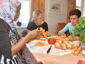 Im Rahmen des Projektes "Paten für Flüchtlinge" wurde im Awo-Treff im Bürglaßschösschen ein gemeinsames Kochen initiiert. Die 22-jährige Sauda aus Äthiopien, die Studentin Anna Keck und der 17-jährige Khaled schnippeln Gemüse.  Foto: Gabi Arnold