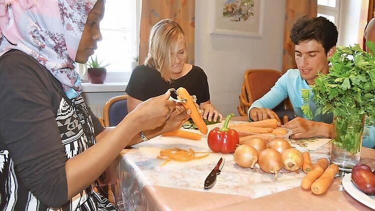 Im Rahmen des Projektes "Paten für Flüchtlinge" wurde im Awo-Treff im Bürglaßschösschen ein gemeinsames Kochen initiiert. Die 22-jährige Sauda aus Äthiopien, die Studentin Anna Keck und der 17-jährige Khaled schnippeln Gemüse.  Foto: Gabi Arnold