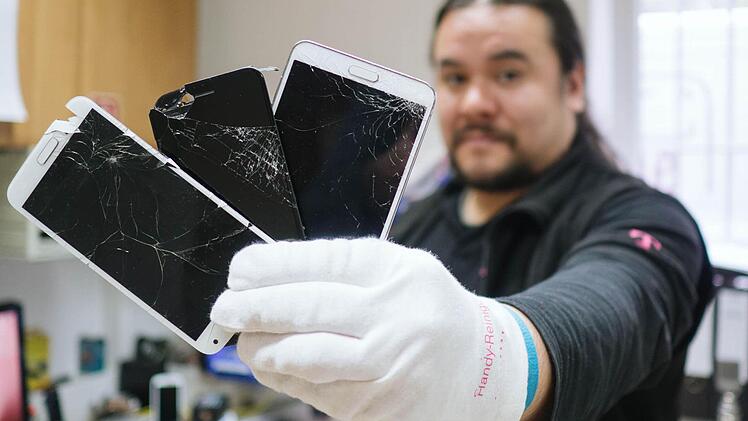 Arbeitsnachweis: Mit zersplitterten Smartphone-Displays hat Christian Wendland beinahe täglich zu tun. Foto: Marian Hamacher