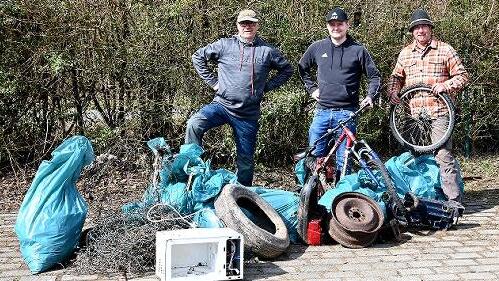 Gewässerwart und Vizevorsitzender Michael Kramer (links) und zwei weitere der insgesamt 25 Müllsammler präsentierten nach Abschluss der Gewässer-Reinigungsaktion entlang der Sinn einen Teil ihrer „Beute“.&#160;&#160;